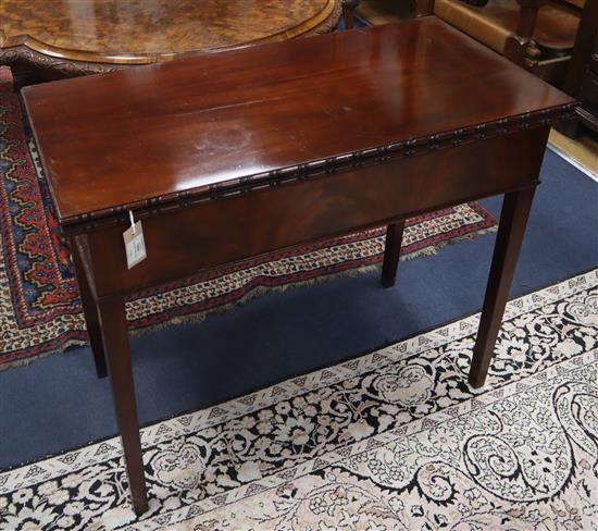 A George III mahogany rectangular topped folding tea table, the moulded edge over a matured veneered frieze and square tapered legs W.9